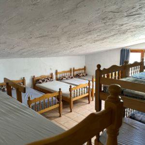 a bedroom with four beds in a room with a ceiling at Granja El Regajo in Valencia