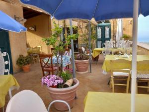 un patio con tavoli, sedie e ombrellone blu di B&B Batarà - "La Terrazza del Centro" a Agrigento