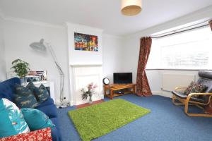 ein Wohnzimmer mit einem blauen Sofa und einem grünen Teppich in der Unterkunft Wolsey Road, North Oxford in Oxford