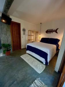 Schlafzimmer mit einem Bett mit Fischkopf an der Wand in der Unterkunft Estudio Lirios seu cantinho ecológico na natureza in Marau