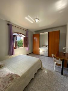 een slaapkamer met een bed, een tafel en een bureau bij Casa Raiz in Valença