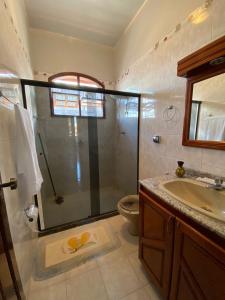een badkamer met een douche, een wastafel en een toilet bij Casa Raiz in Valença