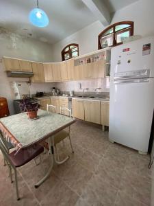 een keuken met een tafel en een witte koelkast bij Casa Raiz in Valença
