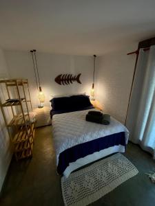 Schlafzimmer mit einem Bett mit einem Kopfteil aus Fisch und Lichtern in der Unterkunft Estudio Lirios seu cantinho ecológico na natureza in Marau