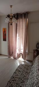 - une chambre avec un lit et une grande fenêtre dans l'établissement Casa Greta, à Iglesias