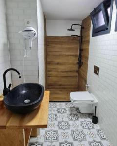 a bathroom with a black sink and a toilet at Usula Bungalov in Rize