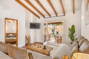un soggiorno con divano e TV di Sensacions Menorca - Villas & Bungalows en complejo Pueblo Menorquín a Son Xoriguer