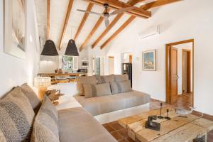 un soggiorno con divano e tavolo di Sensacions Menorca - Villas & Bungalows en complejo Pueblo Menorquín a Son Xoriguer