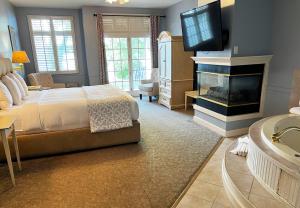 1 dormitorio con 1 cama, chimenea y TV en The Sand Hill Inn, en Lake Geneva