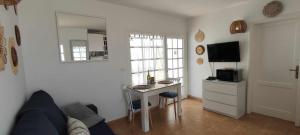 uma sala de estar com um sofá, uma mesa e uma cozinha em Gibshouses Rosa em Puerto del Carmen