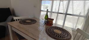 uma mesa com uma garrafa de vinho e um copo em Gibshouses Rosa em Puerto del Carmen