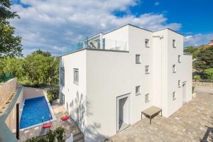 an aerial view of a white building with a swimming pool at Villa Nika in Malinska