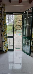 an open glass door with a view of a yard at Voscenza Benerica in Vittoria