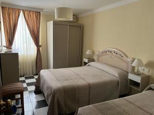 um quarto de hotel com duas camas e uma janela em Hotel Plaza Damasco em Almuñécar