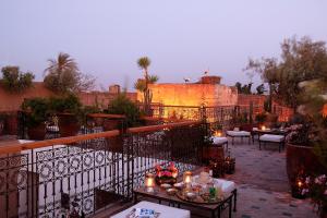 a patio with tables and candles on a balcony at Riad Aladdin in Marrakesh