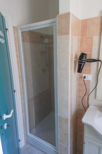 y baño con ducha y puerta de cristal. en Casa Ilaria Calaliberotto, en Cala Liberotto