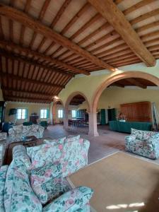 a living room with couches and tables in a building at Agriturismo Caio Alto in Cetona