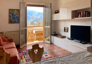 a living room with a flat screen tv and a couch at Mountain view charming apartment in Moggio