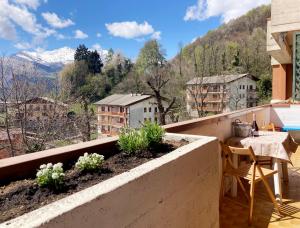 einen Balkon mit einem Tisch, Stühlen und Bergen in der Unterkunft Mountain view charming apartment in Moggio