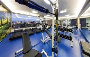 a gym with a blue gym floor with tread machines at Araucária Flat in Ribeirão Preto