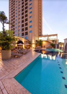 a large swimming pool in front of a building at Araucária Flat in Ribeirão Preto