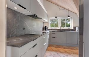 ブラーバンドにあるAmazing Home In Blvand With Sauna, Wifi And Indoor Swimming Poolの白いキャビネットと窓付きのキッチン