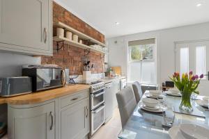 a kitchen with a table and a counter top with a microwave at Exe Riverside Retreat Holiday Home in Exeter