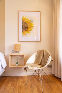 a bedroom with a chair and a painting of a sunflower at Eco-Hotel Doña Mayor in Frómista