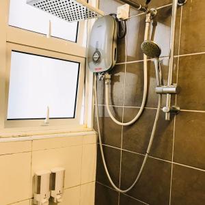 een douche met een douchekop in de badkamer bij Putrajaya 3R2B 10pax Acond Coway WiFi HyppTV Pool Gym Kitchen in Putrajaya