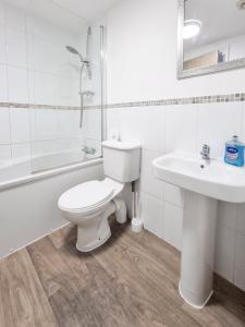 a white bathroom with a toilet and a sink at Milton Keynes 5BR Contractor house, families/ groups welcome. in Broughton