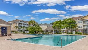 a swimming pool in the courtyard of a apartment complex at Barefoot In The Sun at Barefoot Resort & Golf in North Myrtle Beach