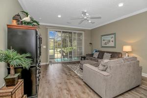 a living room with a couch and a tv at Barefoot In The Sun at Barefoot Resort & Golf in North Myrtle Beach