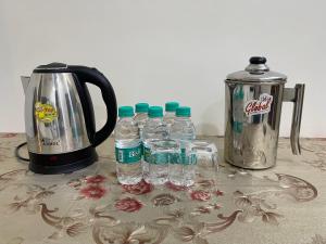 a group of bottles of water next to a coffee maker at Homestay Comforts 500m from Amritsar Airport in Amritsar