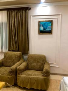 una sala de estar con una silla y una foto en la pared en Guest House Anahit Ijevan, en Ijevan