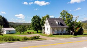 a white house on the side of the road at Mountain View, Hot Tub, Trail Access, Spa in Saint-Raymond
