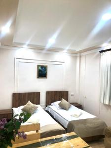 1 dormitorio con 2 camas, mesa y ventana en Guest House Anahit Ijevan, en Ijevan
