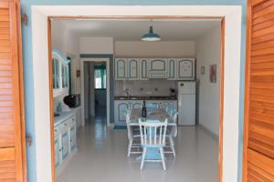 een keuken met blauwe kasten en een tafel en stoelen bij Casa Ilaria Calaliberotto in Cala Liberotto