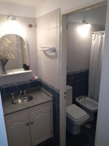 a bathroom with a sink and a toilet and a mirror at Casa de campo El Zoki in Villa Anizacate