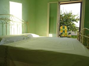 1 dormitorio con 1 cama, 1 silla y 1 ventana en Il MELOGRANO, en Sannicola