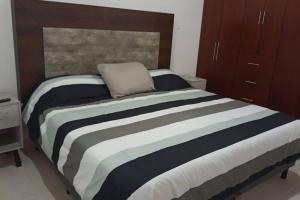 a bedroom with a large bed with a wooden headboard at Casa amueblada, Internet, WIFI, en Yucatán in Mérida