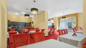 Aphrodite Suite Hotel Karlovy Vary في كارلوفي فاري: غرفة طعام مع طاولات وكراسي حمراء