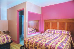 una camera con due letti e pareti rosa di OYO Hotel I-20 Decatur, East Atlanta a Decatur
