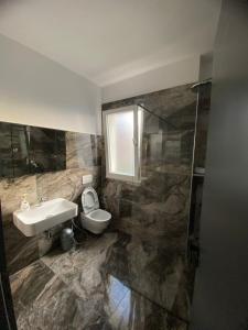 a bathroom with a sink and a toilet and a shower at LEODORI 3 suites in Shëngjin