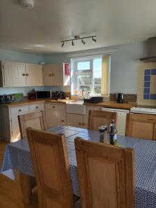 a kitchen with a table and two chairs and a table and a window at Family stay by the beach in Chwilog