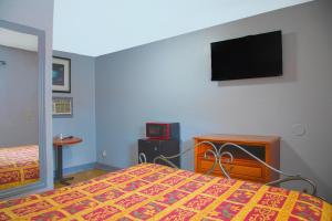 a bedroom with a bed and a tv on the wall at OYO Hotel I-20 Decatur, East Atlanta in Decatur