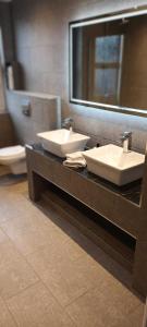 een openbare badkamer met 2 wastafels en een spiegel bij Rydal house with office space newly refurbished in Newton-le-Willows