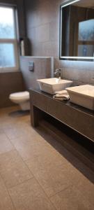 a bathroom with two sinks and a toilet and a mirror at Rydal house with office space newly refurbished in Newton-le-Willows