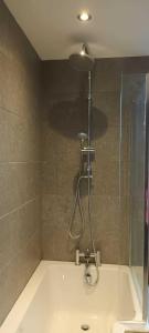 a shower in a bathroom with a bath tub at Rydal house with office space newly refurbished in Newton-le-Willows