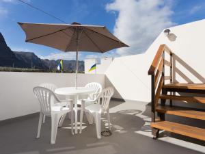 a white table and chairs and an umbrella on a roof at Esquina de Alberto N1 con WiFi, cerca de la playa en Garachico - ES-279-3 in Garachico