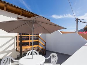 d'une table, de chaises et d'un parasol sur le balcon. dans l'établissement Apartamento La Caleta de Interián, 1 dormitorio, 2 personas - ES-279-5, à Garachico